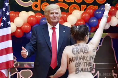 Напівгола активістка Femen схопила воскового Трампа за геніталії. Охорона безуспішно намагалася прикрити дівчину, яка в оголеному вигляді викрикувала гасла.
