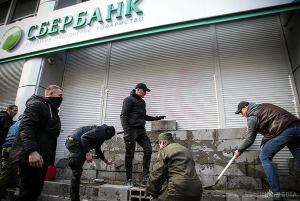 Що буде далі? Радикал був дуже рад, розкурочив банкомат. Вдень 13 березня Національний корпус "Азов" і "Правий сектор" звели символічну стіну між Україною і Росією. Замурували цеглою вхід в головний офіс Ощадбанку, який знаходиться на вулиці Володимирській по сусідству з СБУ.