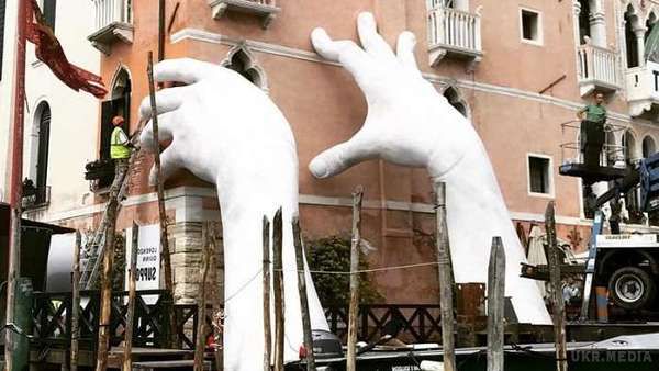 У Венеції з'явилася цікава скульптура гігантських рук (ВІДЕО). Цікаву скульптуру гуманістичного змісту встановили у Венеції. Це білі гігантські руки, що виринають з води і пальцями впираються в будівлю.