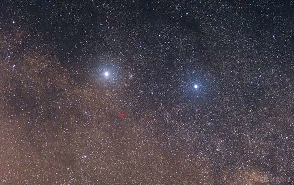 Вчені взялися за вивчення клімату екзопланети Proxima B. Дві яскраві зірки Альфа Центавра зліва і Бета Центавра праворуч. Слабка червона зірка в центрі червоної колу - Проксима Центавра