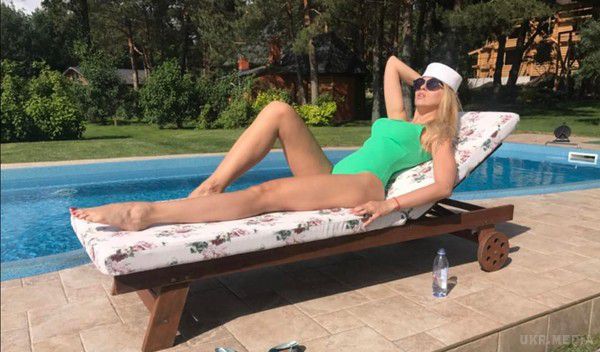Оля Полякова в купальнику відпочиває на дачі (фото). На фото артистка позує на шезлонгу біля басейну.