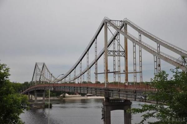 Жахлива трагедія: Прогулянка Пішохідним мостом стала фатальною для киянина (відео). Хлопець намагався залізти на верхівку опори моста і впав.