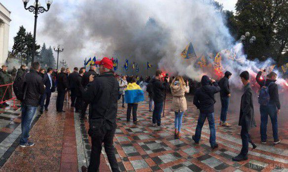 Під Радою протестують проти закону про реінтеграцію Донбасу палять фаєри. Візуально під парламентом зібралися кілька десятків молодих людей з прапорами ВО "Свобода", "Національного корпусу" і "Правого сектора". 