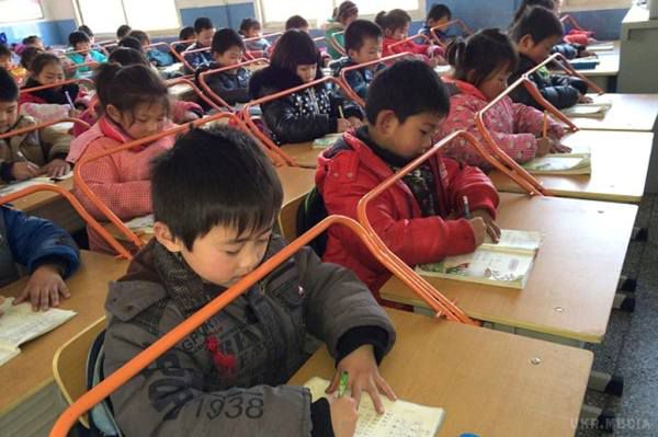 Таким нехитрим способом в школах Китаю зберігають поставу дітей. Ніхто не просить дітей сидіти правильно – по-іншому не вийде