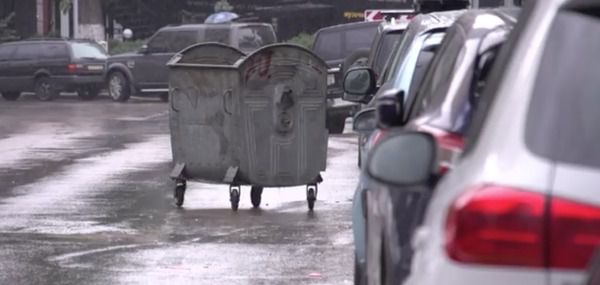 У Києві сміттєвий бак під час зливи "носився" по вулиці і псував машини. Очевидці показали кадри.