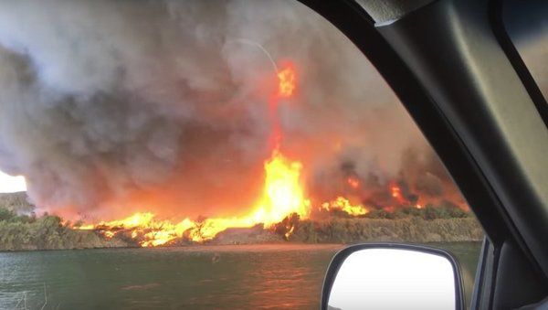 Сімейна пара зафіксувала на відео, як вогненний вихор перетворюється у водяний смерч. Жінка вирішила зняти пожежу на відео, але в підсумку зняла куди більш рідкісне природне явище.