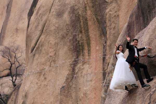 У Китаї відбулося весілля, яке побило всі рекорди з оригінальності і неймовірності!. Молодята відзначили найважливіший день в житті, зависнувши на горі.
