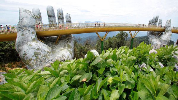 Гігантські руки нового мосту в Дананге, В'єтнам. Вздовж мосту висаджені квіти.