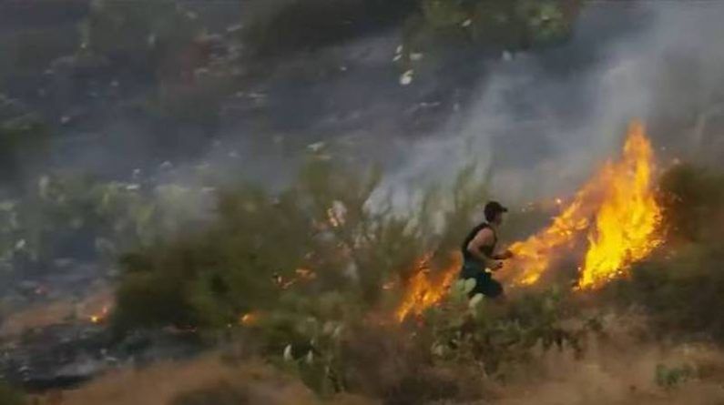 Чоловік під час пробіжки побачив пожежу і стримував полум'ям власними ногами до прибуття пожежників. На відео, яке зняли очевидці, чоловік відчайдушно топче охоплену вогнем ділянку землі, щоб зупинити полум'я.