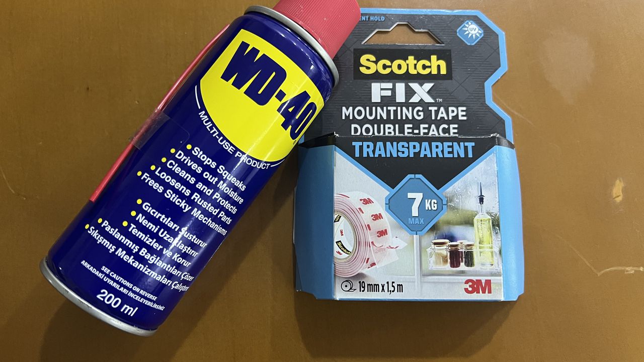 WD-40 спрей та упаковка двостороннього скотчу 3М Scotch Fix, необхідні для видалення клейкої основи з лобового скла.