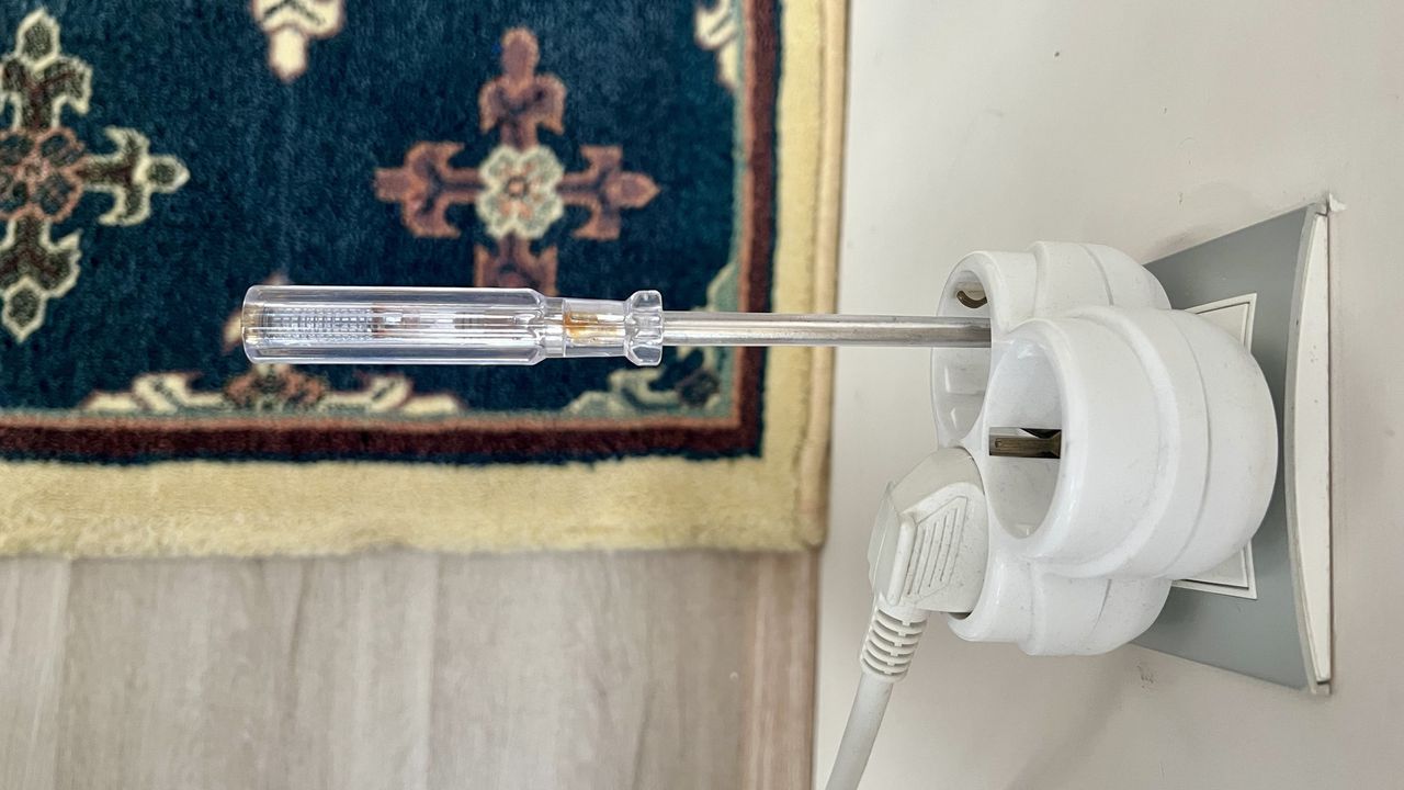 Перевірка наявності фази в електричній розетці за допомогою індикаторної викрутки, без дотику пальцем.