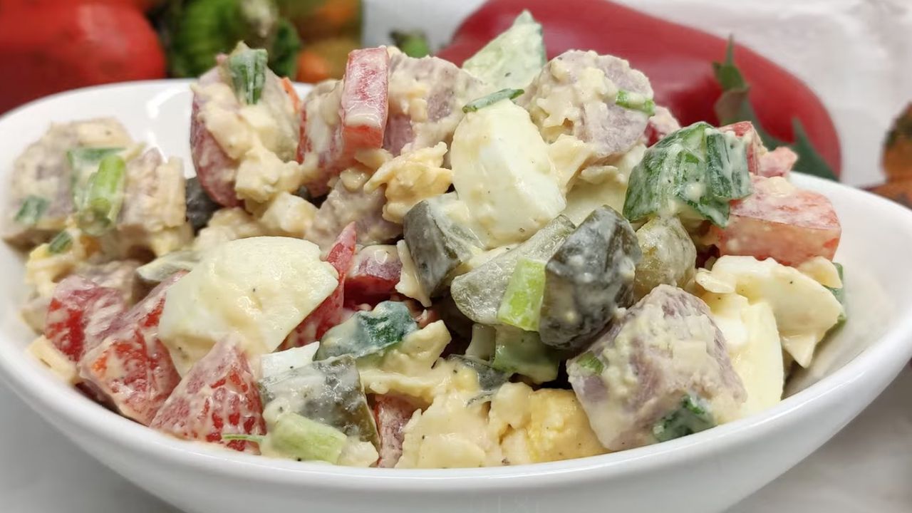 Святковий салат "Берлінський" зі смачною заправкою, яйцями та овочами у білій тарілці.