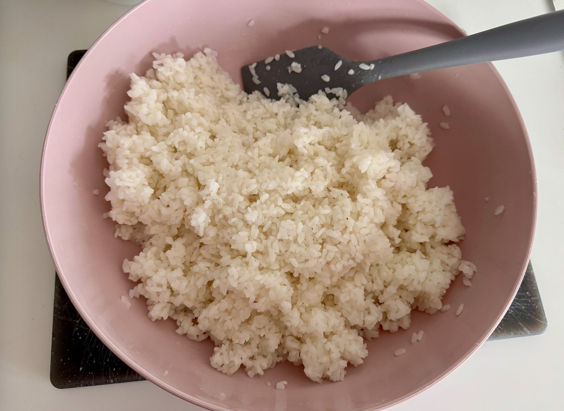 Готовий варений рис у рожевій мисці, приготований за японським рецептом.