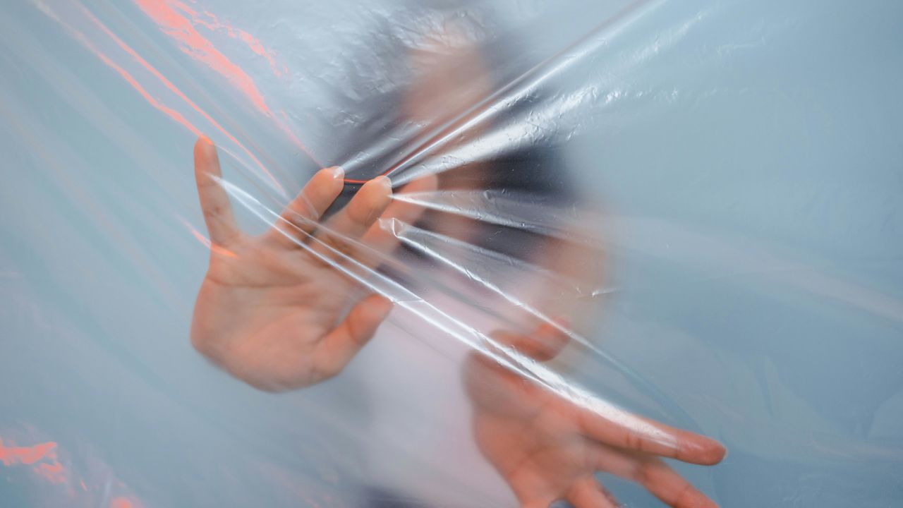 Жінка за прозорою плівкою як метафора синдрому «хорошої дівчинки» та психологічних пасток мислення, що обмежують свободу.