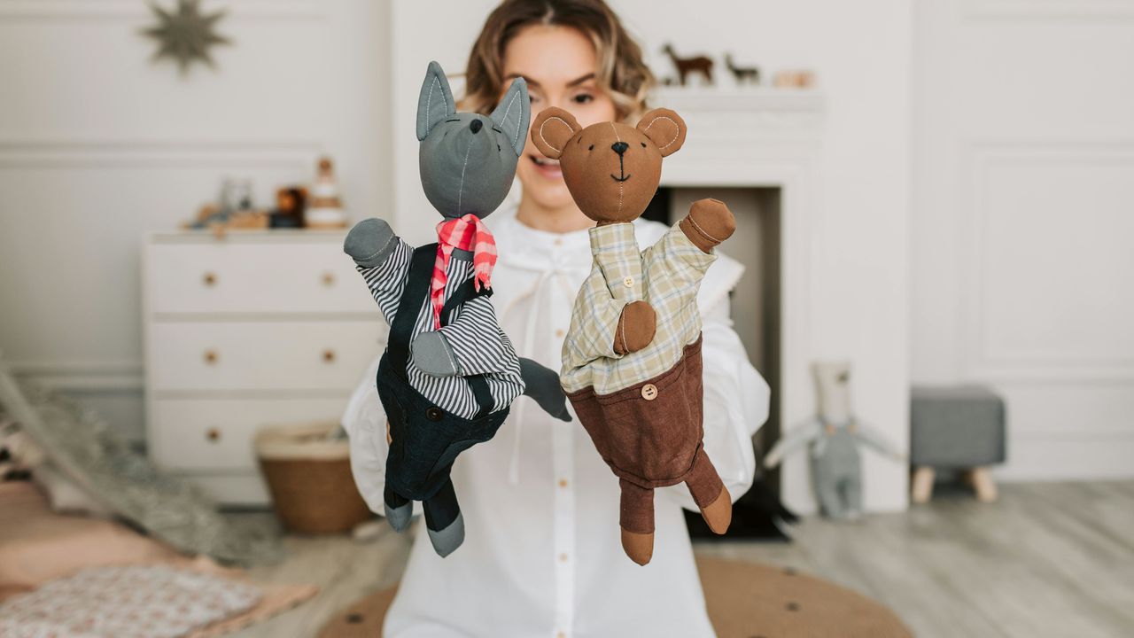 Жінка тримає ляльки-рукавички, що символізує знаки Зодіаку — головних маніпуляторів та майстрів «ляльководства».