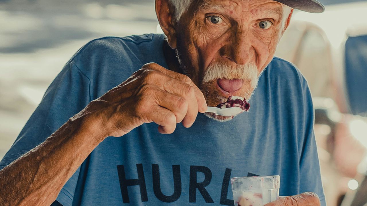 Літній чоловік їсть корисну їжу, ілюструючи дослідження вчених про секрет довгожителів та здорове старіння.