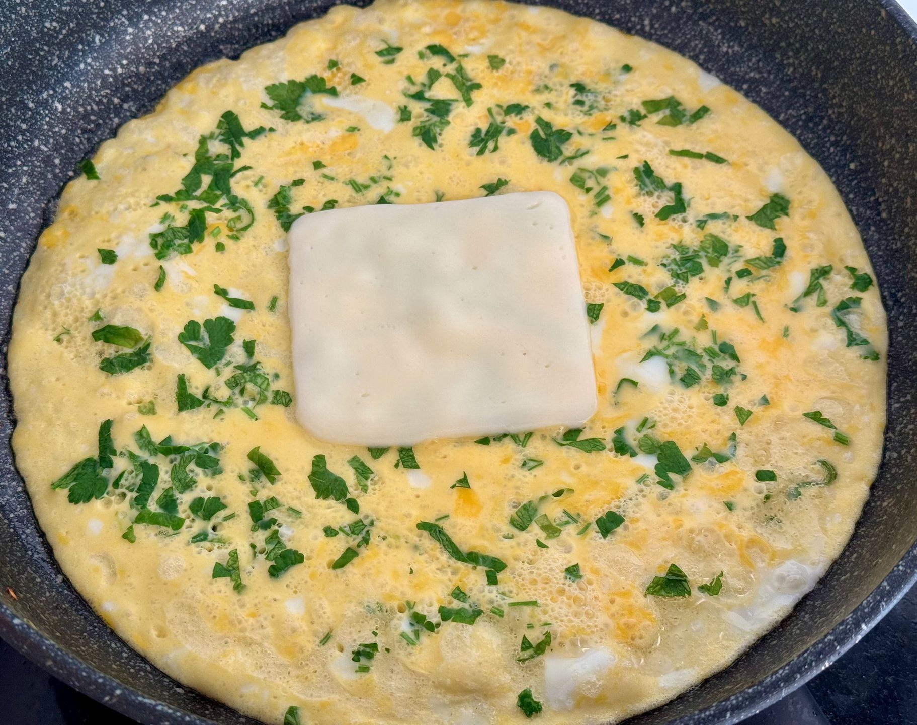 Коли яєчна суміш загусне — викладаємо на неї шматочок сиру.