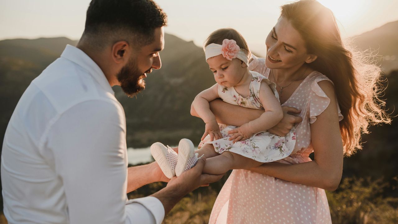 Щаслива молода сім'я з дитиною на фоні гір.