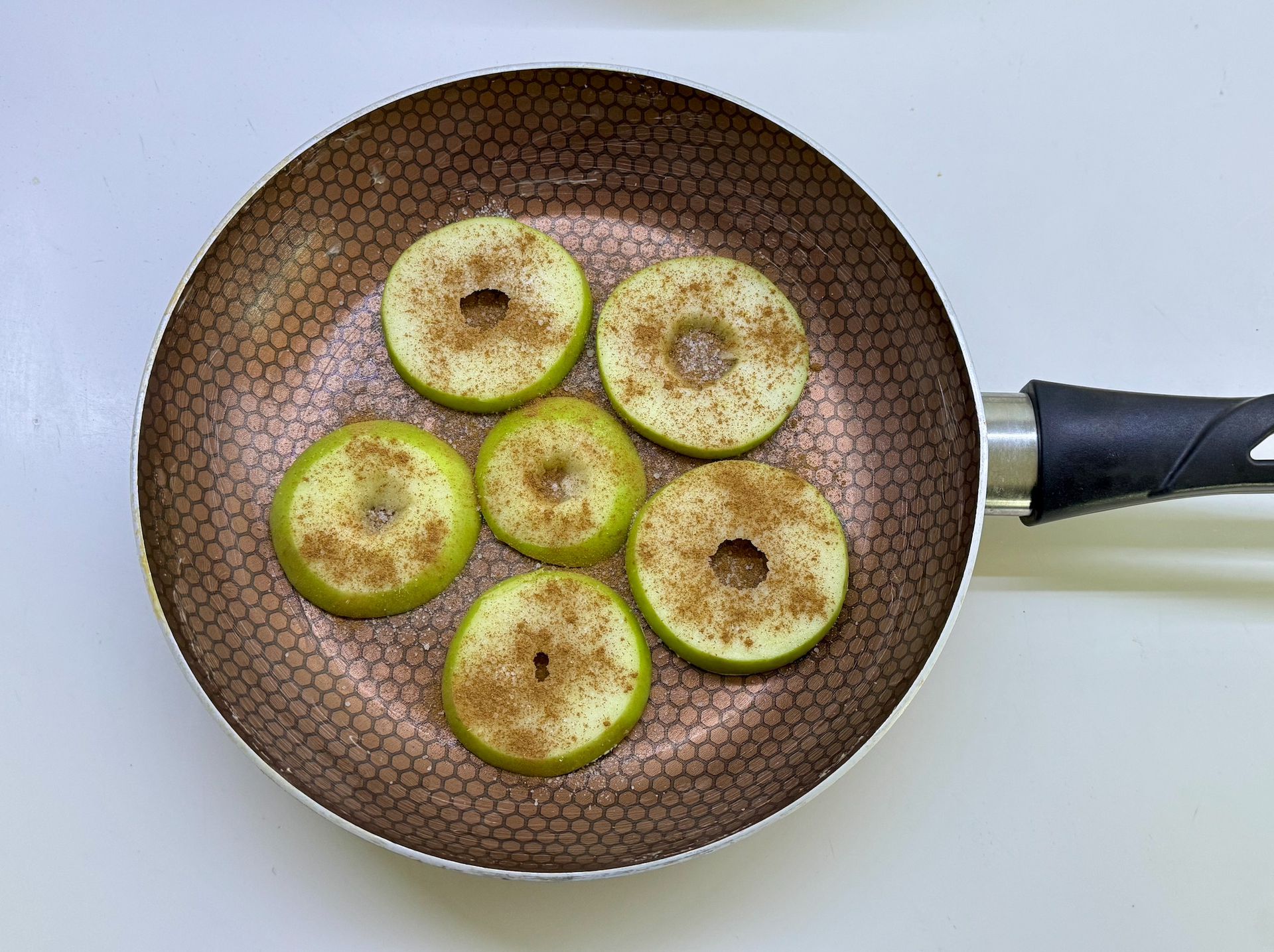 Підготовка яблук у сковороді для приготування шарлотки без духовки
