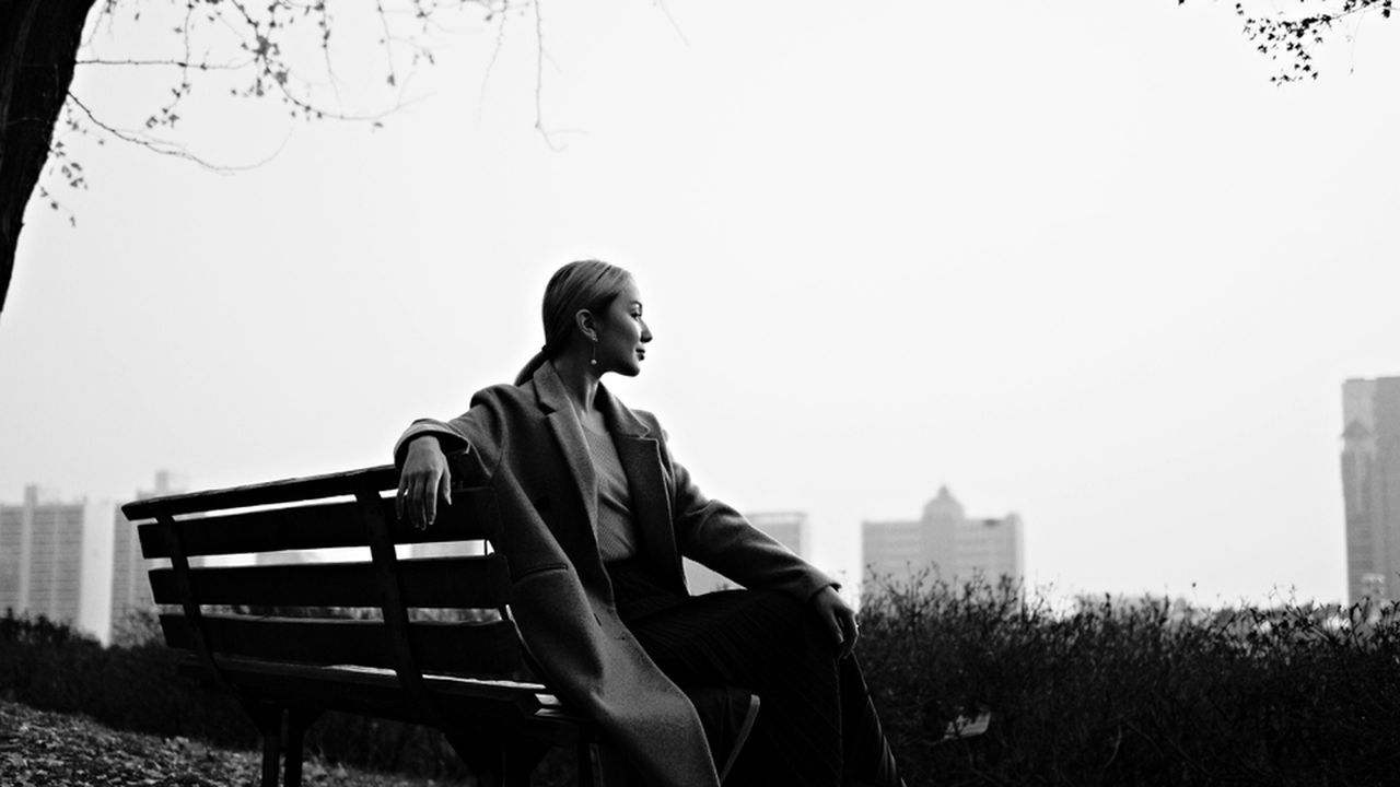 Самотня жінка сидить на лавці в парку, ілюструючи страх самотності та роздуми про те, як не впасти у відчай, коли всі подруги заміжні.